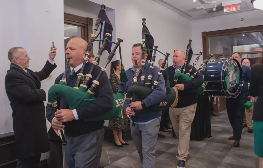 Pipers and drummers parade through City Hall at pre-parade reception